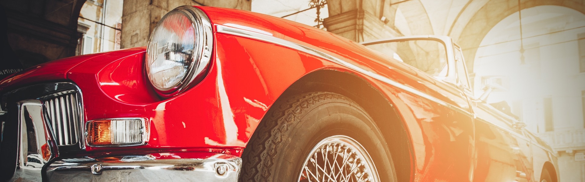 Front view of red shiny classic vintage car. Retro toned postcard, poster.